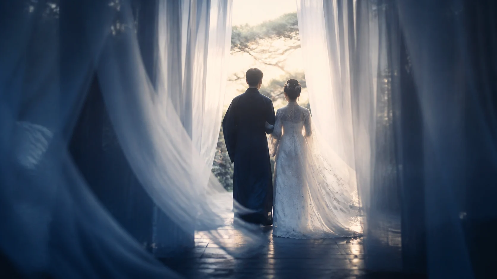 Couple walking through translucent curtains toward a garden